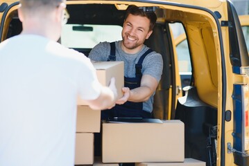 Courier service for the delivery of goods. Express service a man in a uniform delivers boxes. The employee carries the order home to the client.