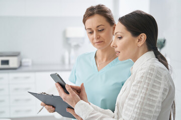 Woman with cellphone talking with doctor in beauty salon