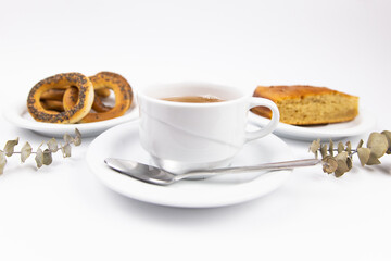 a white tea set with teapot tea and saucers and pie for breakfast