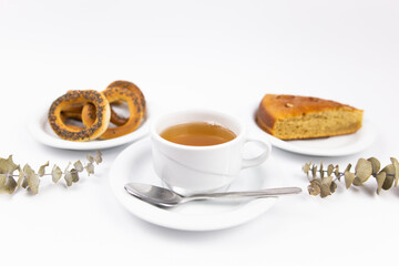 a white tea set with teapot tea and saucers and pie for breakfast