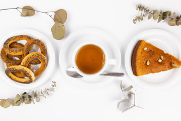 a white tea set with teapot tea and saucers and pie for breakfast