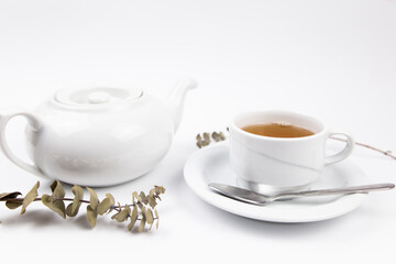 a white tea set with teapot tea and saucers and pie for breakfast