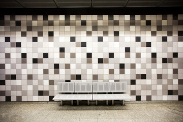 ławeczka na peronie metra z mozaiką w tle