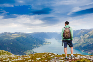 Naklejka na ściany i meble Freedom traveler man standing upper the fjord and enjoying a beautiful nature