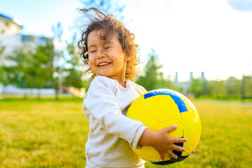 afro american little girl with curly hair playing ball outdoors