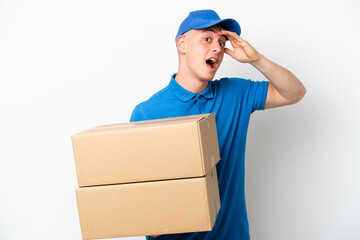Young delivery Brazilian man isolated ops white background doing surprise gesture while looking to the side