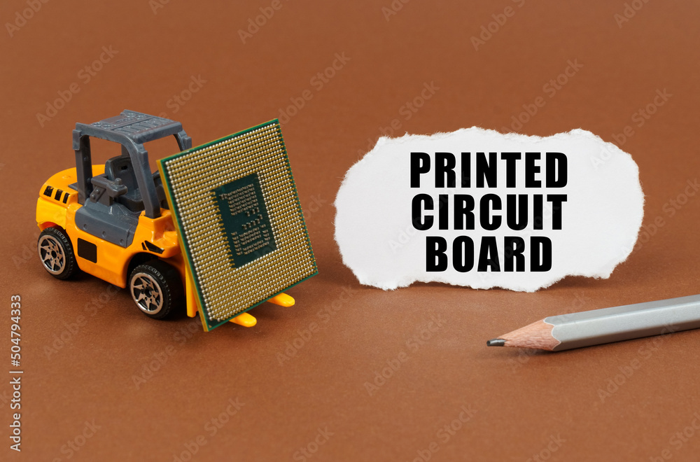 Poster On the table, the loader transports the processor, next to it is paper with the inscription - Printed Circuit Board