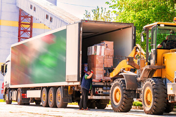 Loader unloads pallets with goods.