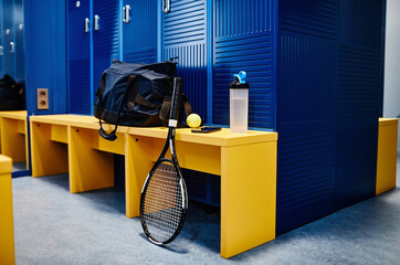 Background image of tennis racket and sports equipment in locker room in vibrant blue color, copy...
