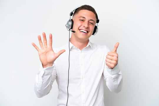 Telemarketer Brazilian man working with a headset isolated on white background counting six with fingers