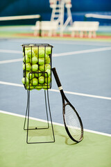 Vertical background image of tennis racket and ball basket at tennis court, copy space