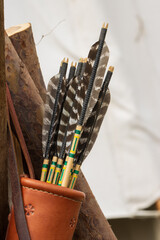 leather bow quiver with feathered arrows, arrow building