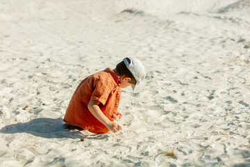 Little boy play with sand on a beach
