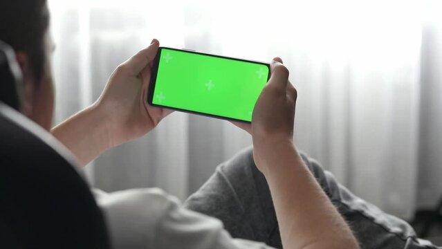 guy playing green screen phone at home