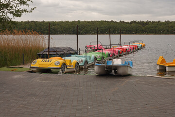 Lots of colorful pedal boats on the lake shore - obrazy, fototapety, plakaty