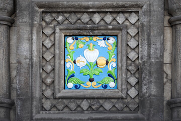 Colorful tile, glazed enamel. Antique ceramic tile adorn a stone wall of an old building