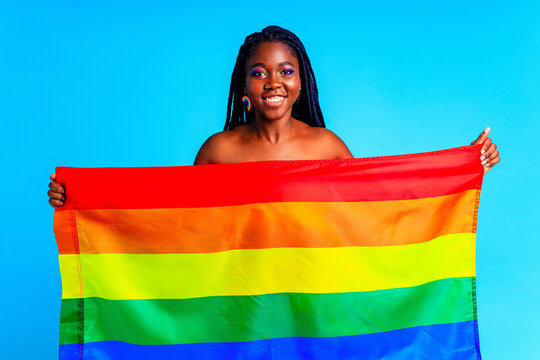 woman covering the body with a flag in blue studio background