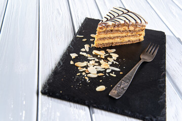 A piece of Esterhazy cake on a black board.