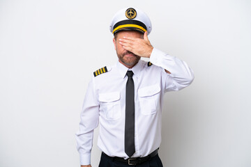 Airplane middle age pilot isolated on white background covering eyes by hands. Do not want to see...