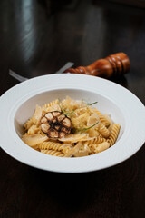 Pasta with herbs. Traditional Italian dish served on restaurant table.