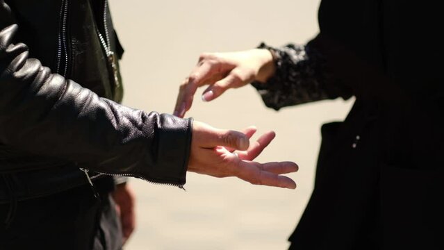 Hands of lovers connection. Close-up of hands joining together with solar flares in the background.