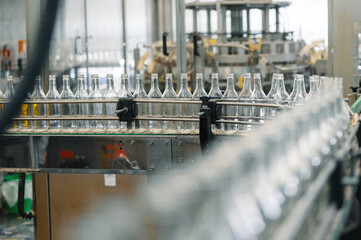 Production line transports empty glass bottles for alcohol