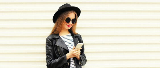 Portrait of stylish woman with smartphone wearing black round hat on white background, blank copy...