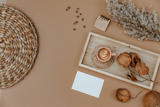 Minimal aesthetic business brand, blog, social media template. Blank card, coffee cup and dry leaves on neutral background. Flat lay, top view