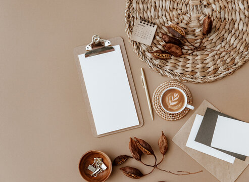 Home office desk workspace. Business, work template. Flat lay, top view. Blank paper sheet, calendar and coffee cup on beige concrete background. Flat Lay