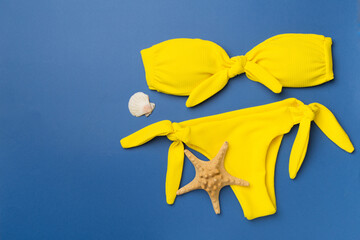 Beautiful yellow bikini on color background, top view