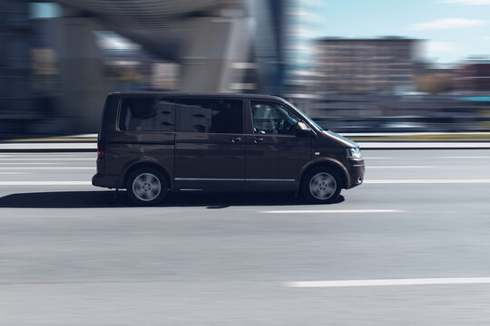 Fast moving Volkswagen Multivan T5 on the city road. Brown van is riding on street. Commercial auto in fast motion with blurred background. speeding in the city concept