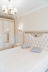 beautiful retro bedroom interior with a large classic bed with a soft headboard.