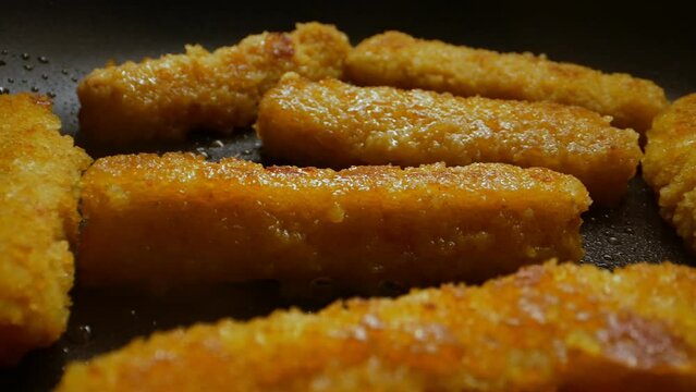 Chicken nuggets frying in a pan.