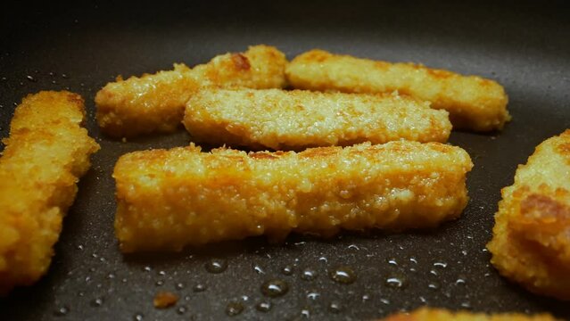 Chicken nuggets frying in a pan.