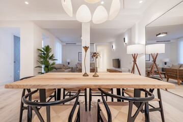 dining table made from a wooden plank with matching metal and natural fiber chairs in a vacation rental apartment