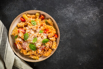 Traditional italian pasta with basil and parmesan on dark table. Top view with copy space.