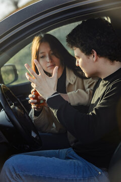 a young beautiful girl quarrels with her boyfriend who wants to drink alcohol while driving a car, alcohol dependence and codependency