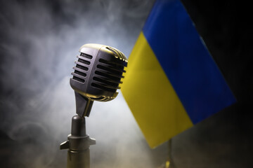 Microphone on a background of a blurry flag Ukraine close-up - obrazy, fototapety, plakaty