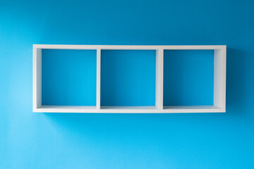 Beautiful empty cube shelves on a stunning  blue wall