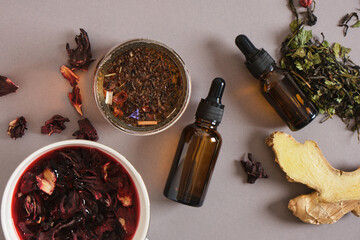 dropper bottles and hibiscus brewed tea on a gray background, culminating drinks concept, adaptogens