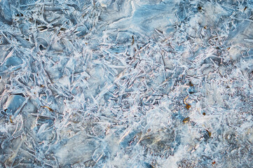 Thin ice in the morning on a rocky beach. Sunrise. Night frosts. Close view. Natural abstract...