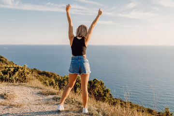 Happy woman in nature at warm sunset. Happy holiday at sea coastline