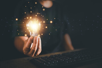 Man hand holding light bulb and using keyboard of computer , New idea creativity concept,...