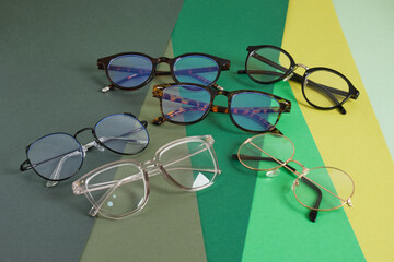 several trendy stylish pairs of eye glasses on a geometric background of different shades of green