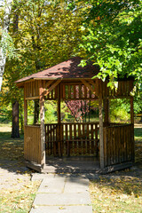 Wooden gazebo in the forest or park under the sun
