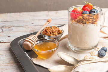 Granola with nuts, yogurt and red fruits berries in a jar. Breakfast parfait with muesli, yoghurt,...