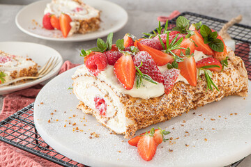 Meringue roll with a gentle airy cream, crunchy peanut, mint, rosemary and filling with raspberries and strawberries. Pavlova summer sweet dessert