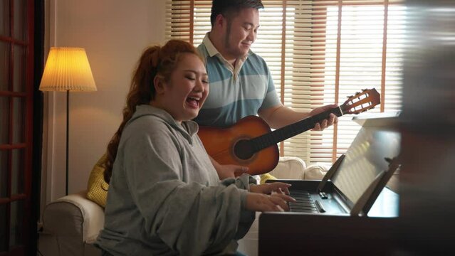 Romantic happy fat asian couple happy to play music