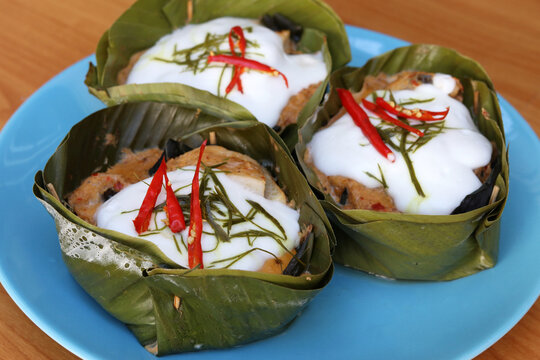 Cultural Thai food recipe, Steamed curry fish wrapped in banana leaves or Homok pla. Ingredients cooked in banana leaves include fish, vegetable, herb, chili and topping with coconut milk. 