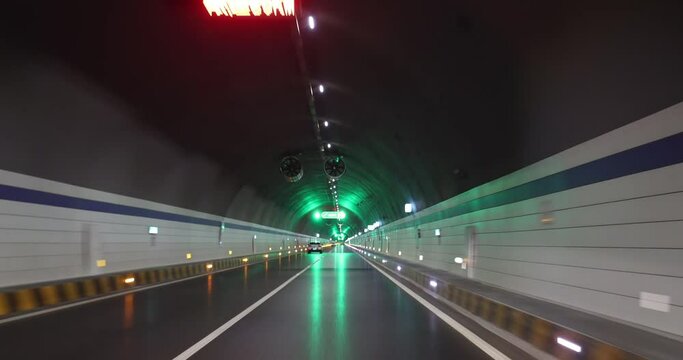 Driving car in a tunnel. Words in the footage means speed limitation at 80km per hour, the tunnel's name